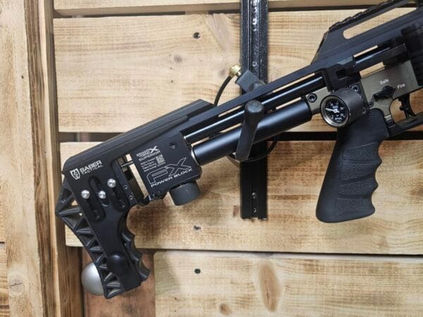FX Airguns Impact M3 air rifle mounted on a wooden display with a black grip and adjustable stock.