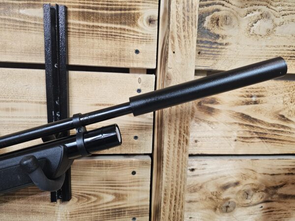 Air gun with a suppressor attached, mounted on a wooden wall.