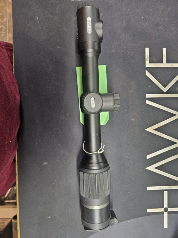 Hawke rifle scope with adjustable magnification and focus features on a dark surface.