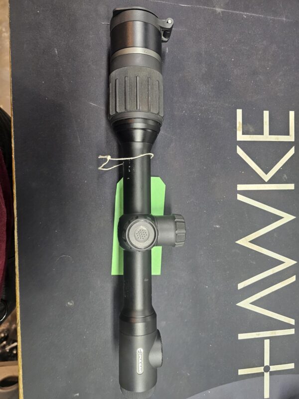 Hawke rifle scope with adjustable magnification and focus features on a dark background.