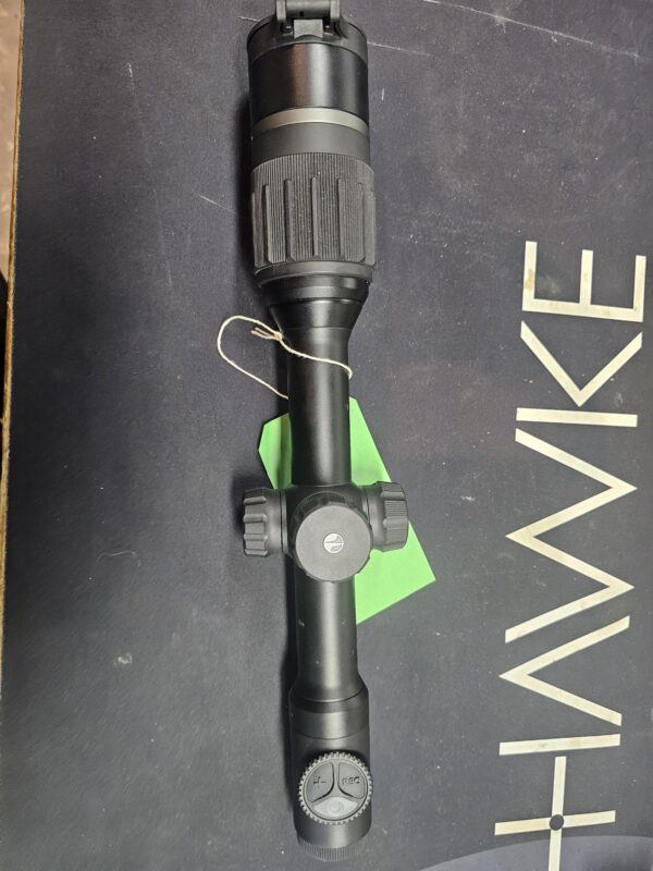 Hawke rifle scope with adjustable zoom and focus features displayed on a dark surface.