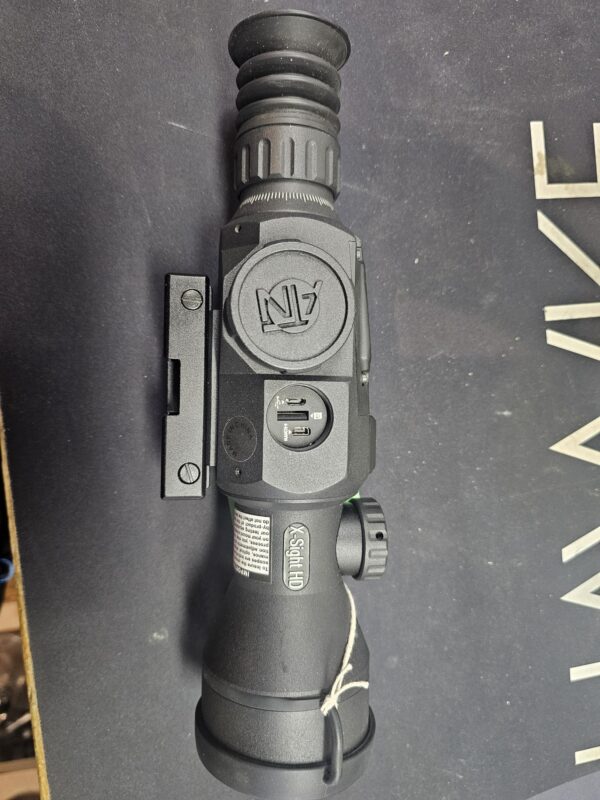 A night vision scope with a black body and various adjustment features.
